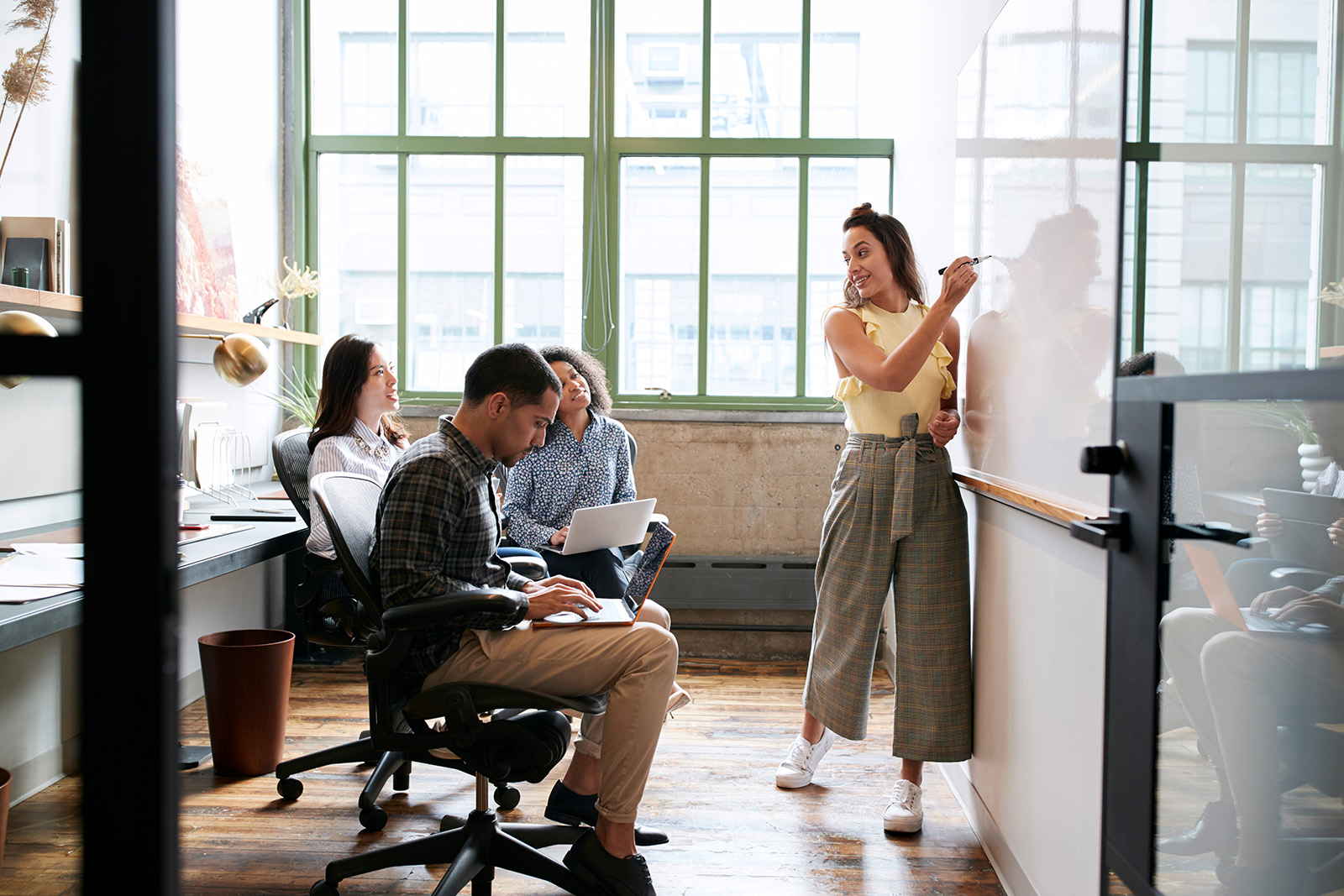 Woman using whiteboard in a small team meeting