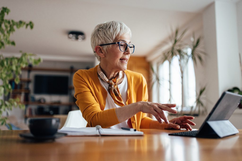 Mature woman, explaining something to her coworkers, online.