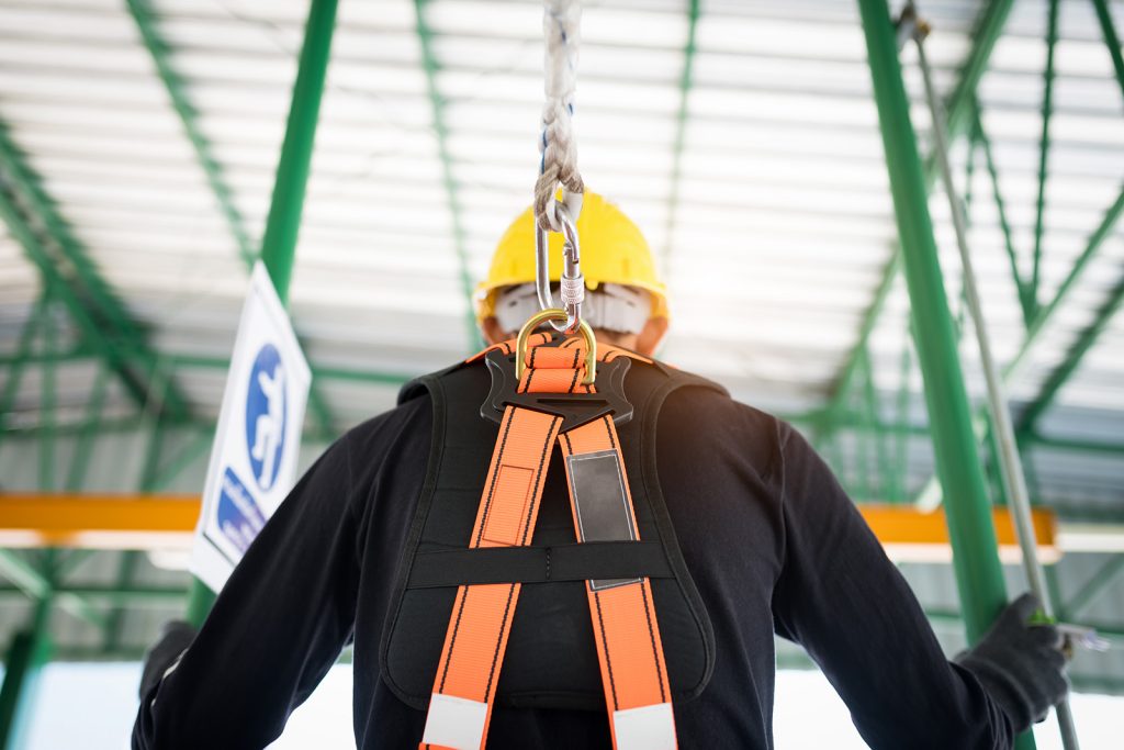 Construction worker wearing safety harness and safety line working at hight